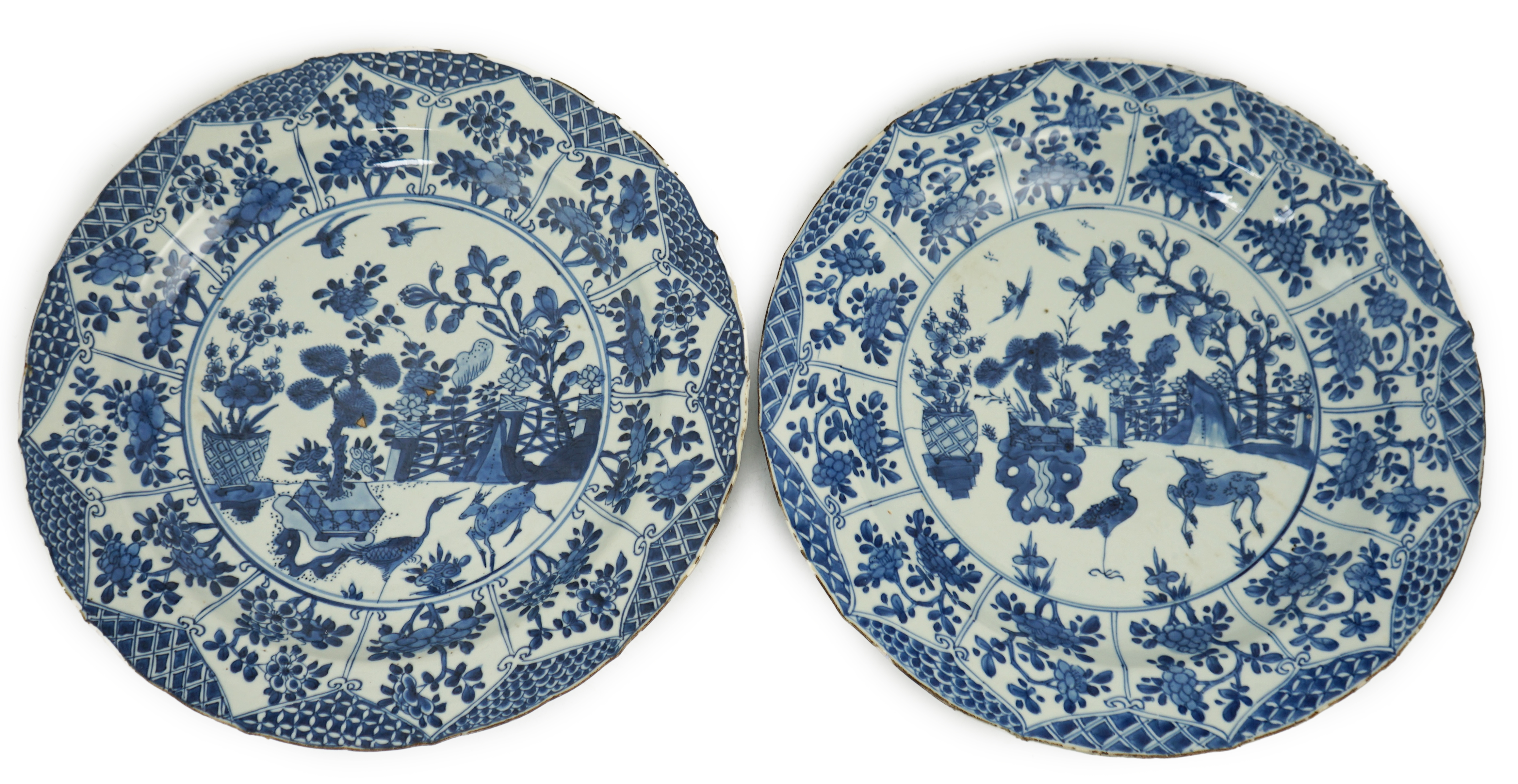 A pair of Chinese blue and white ‘garden’ dishes, Kangxi period, fritting and glaze chips